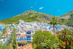 Blue-washed houses of Chefchaouen below the green Rif mountains