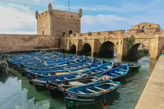Blue fishing boats in Essaouira harbour below the Skala citadel walls