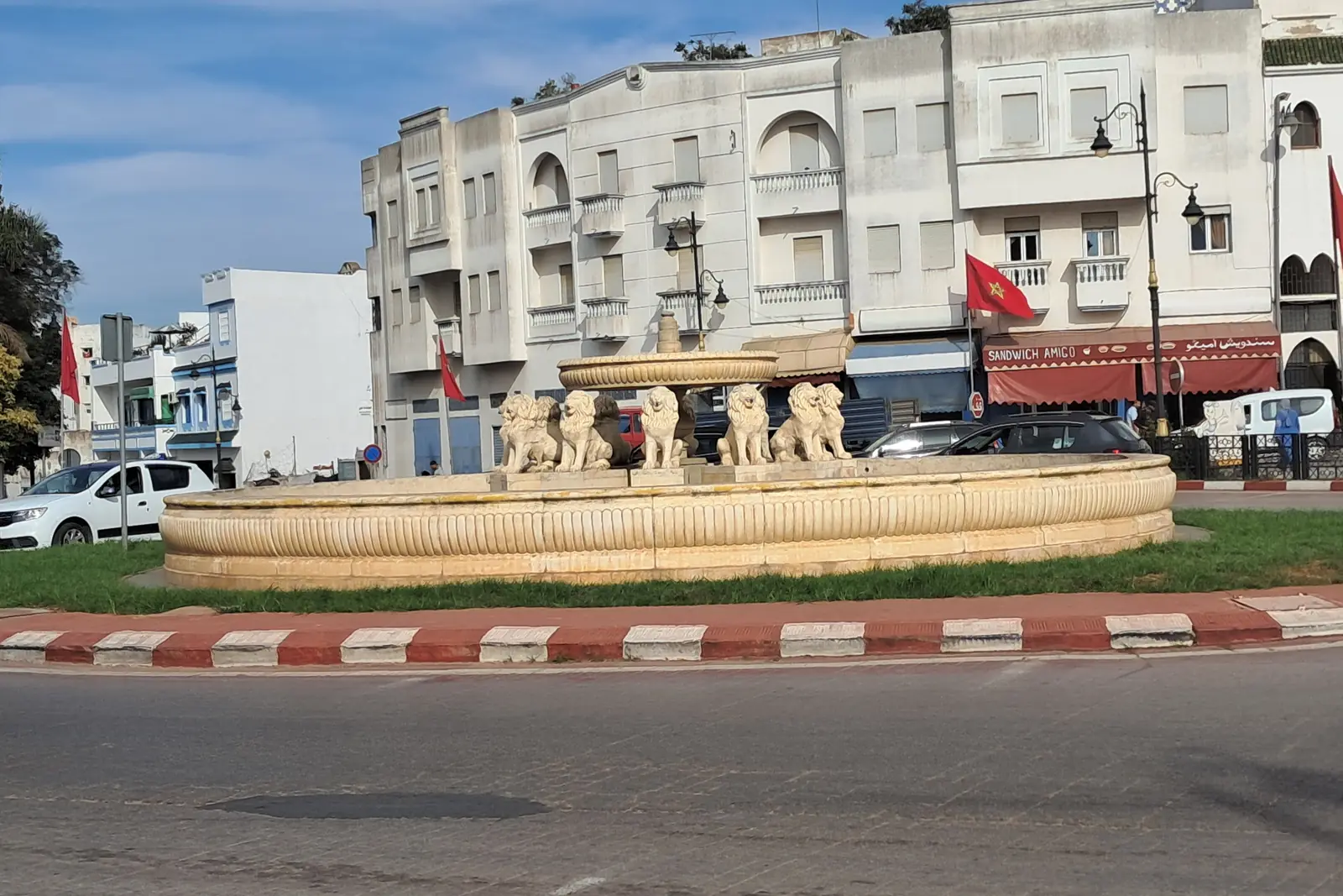 Fountain on a roundabout in Larache with white colonial-era buildings