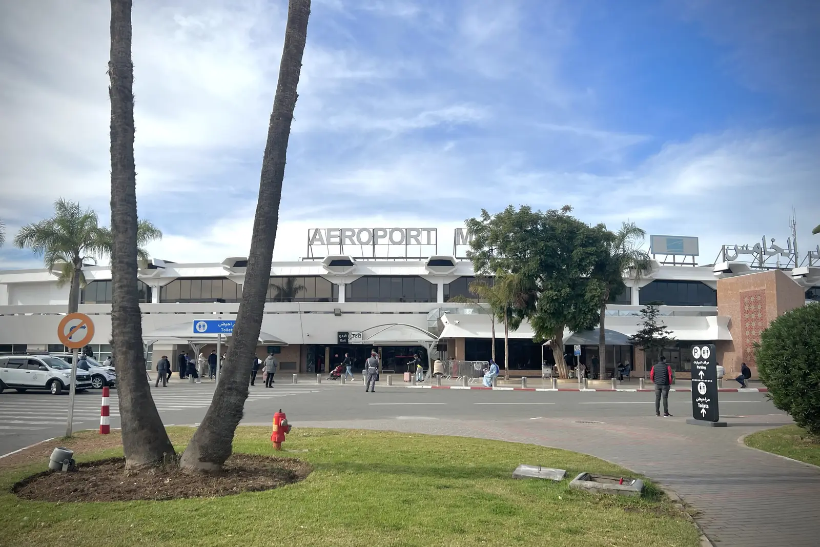 Front of Mohammed V International Airport (CMN), Casablanca, with palm trees and the AEROPORT sign in daylight
