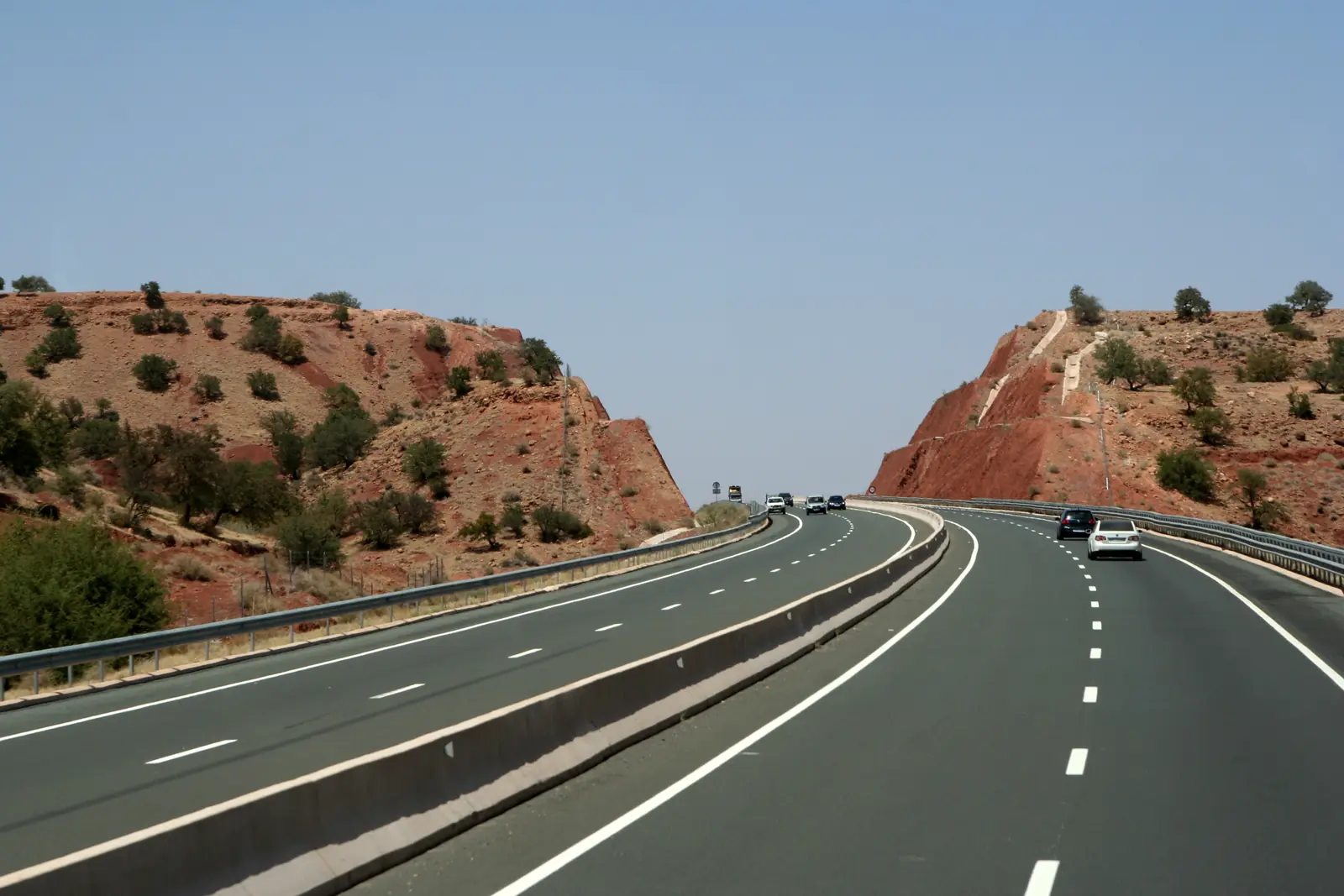 A7 motorway in Morocco cutting through red hills on a clear day